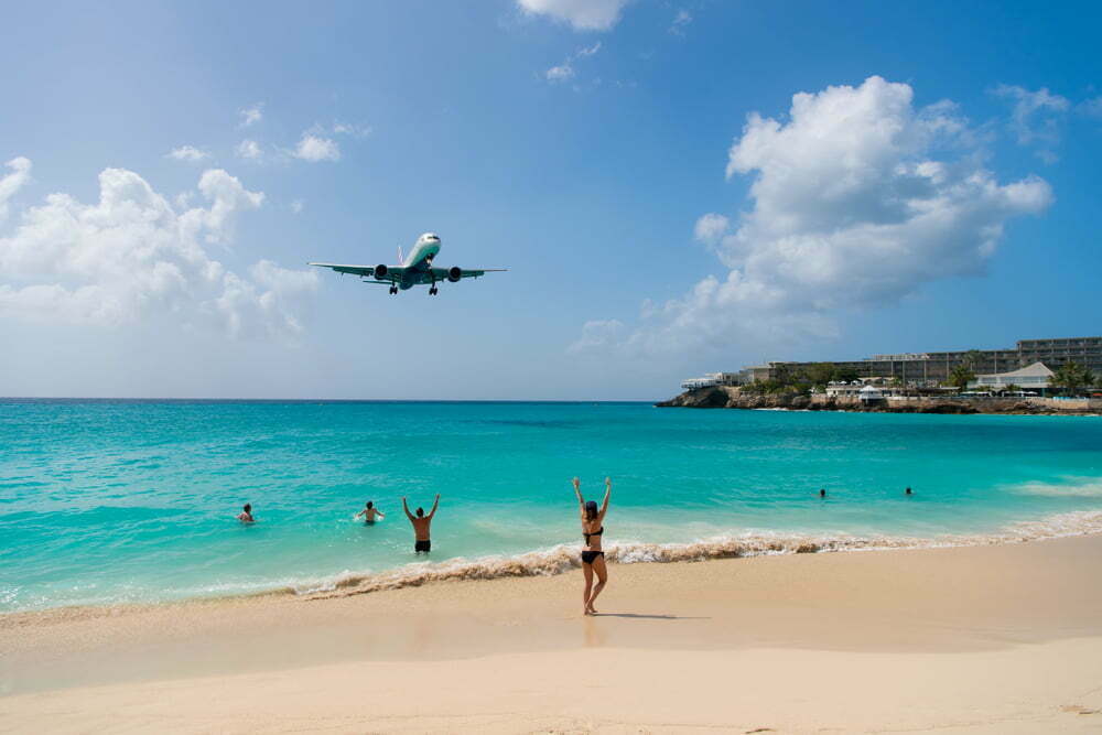 Plane,Land,Over,People,On,Beach,Of,Philipsburg,,Sint,Maarten.