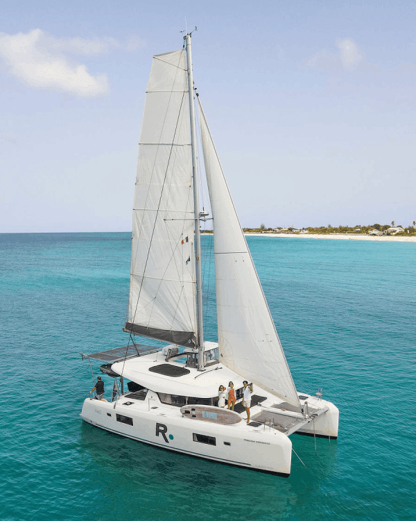 Three people enjoy drinks aboard the Freedom, Sail Renegades private charter boat sailing to St. Maarten in the Caribbean
